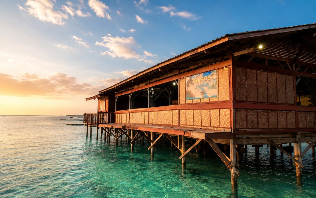 Bangunan kayu di atas laut dengan air laut biru jernih, langit cerah, dan suasana resor tropis yang bersih serta nyaman untuk berlibur