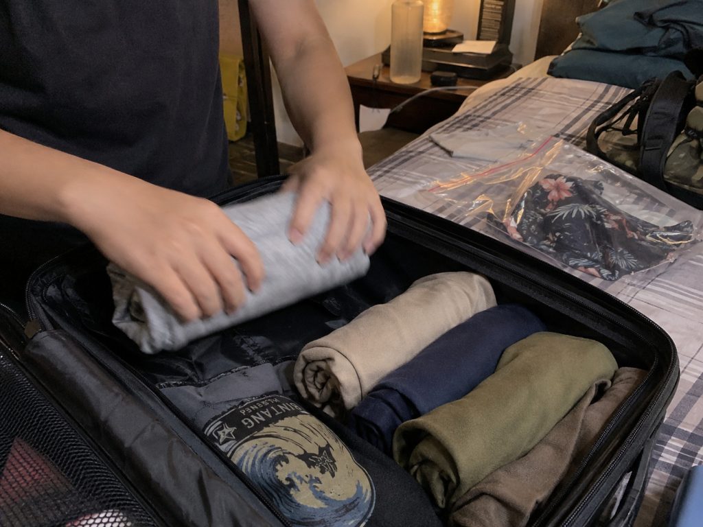 Susunan baju digulung rapi di dalam tas untuk menghemat ruang saat packing liburan pulau