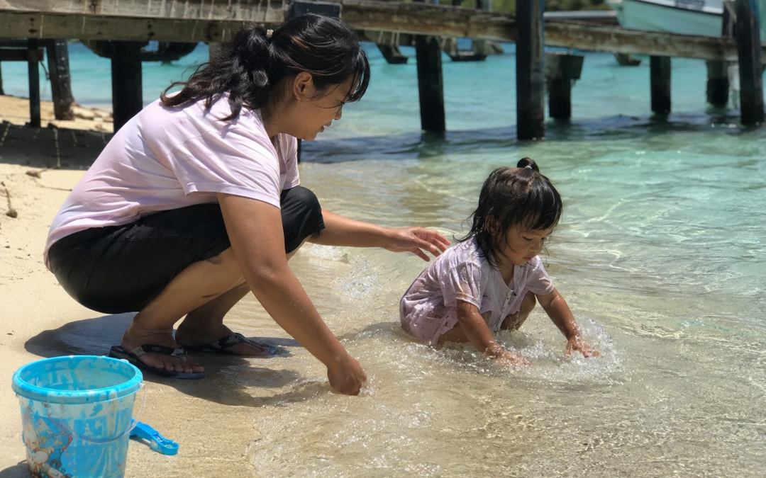 Orang tua mengawasi anak bermain air di area dangkal Pulau Tidung